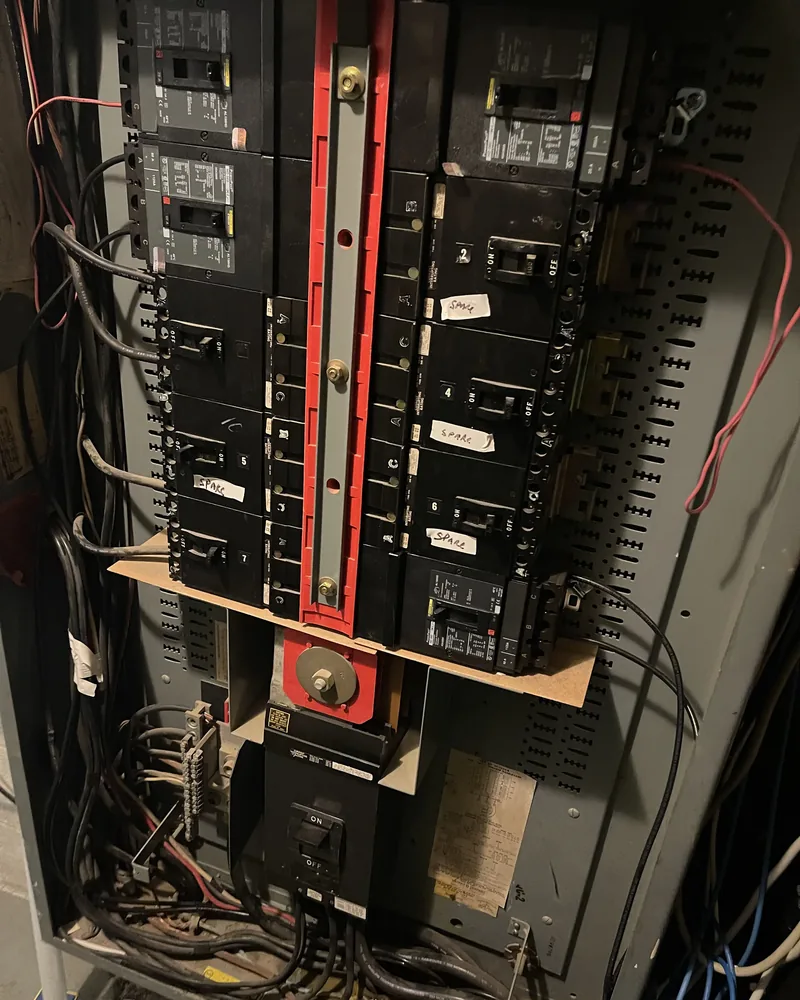 Open commercial distribution panel with breakers marked as spares during electrical work
